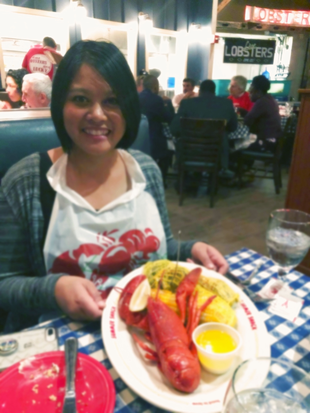 Leng smiling at a restaurant table with a travel journal and camera